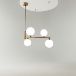 Lampa wisząca Ring 4-punktowa w kolorze mosiądzu, z czterema okrągłymi, białymi kloszami. Montowana sufitowo, z poziomym ramieniem. Prosta, nowoczesna konstrukcja na czarnych kablach, w minimalistycznym otoczeniu.