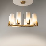 Lampa wisząca Fortano MOD089PL-10BS z dziesięcioma punktami świetlnymi. Metalowa konstrukcja w kolorze złotym z matowymi, białymi kloszami w formie cylindrów. Ujęcie frontalne, zawieszona na cienkim drucie. Proste tło.