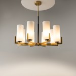 Lampa wisząca Fortano MOD089PL-08BS z ośmioma mlecznymi kloszami w kształcie cylindrów, zawieszona na złotej konstrukcji. Klosze umieszczone na ramionach w układzie promienistym, wisi pod okrągłym, metalowym mocowaniem. Tło szare, minimalistyczne.