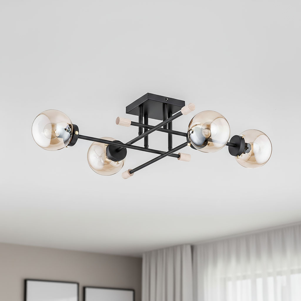 Lampa sufitowa Transfer 4-punktowa, czarna. Konstrukcja z metalowymi ramionami i szklanymi kloszami w kolorze bursztynowym. Ujęcie z góry, produkt zamontowany na suficie, w tle jasne wnętrze z zasłonami.
