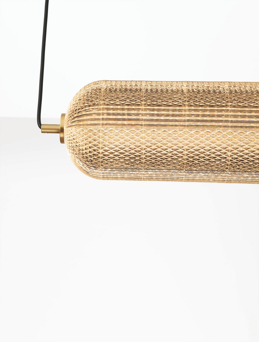 Lampa wisząca Tipuani 1xLED 40W w złotym kolorze, o cylindrycznym kształcie z siateczkową strukturą. Zawieszona na czarnym przewodzie, widok z boku. Idealna do nowoczesnych wnętrz.