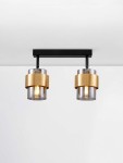 Lampa sufitowa podwójna Vieja z czarnym metalowym stelażem, dwa klosze w kolorze złotym z przezroczystymi akcentami. Ujęcie frontalne, zawieszona pod sufitem, z widocznymi żarówkami E27 w środku. Proste tło.