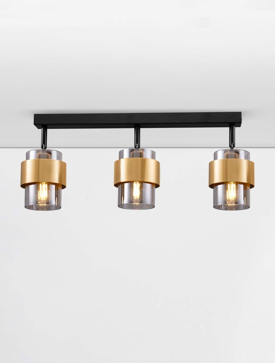 Lampa sufitowa Vieja z trzema oprawami E27 w kolorze czarnym. Każda oprawa ma złote wykończenie i przezroczystą osłonę, zamontowana na prostokątnej podstawie. Produkt zawieszony równolegle do sufitu, na jasnym tle.