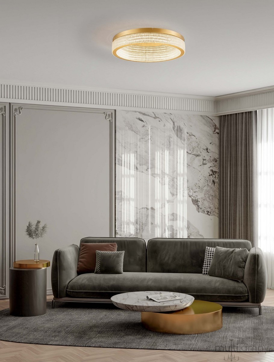 Lampa sufitowa Yotau 1xLED 70W w kolorze złotym, okrągła, z przezroczystym wzorem. Zainstalowana na suficie w nowoczesnym wnętrzu, otoczona szarymi zasłonami i eleganckim meblem, tworzy stylowy akcent oświetleniowy.