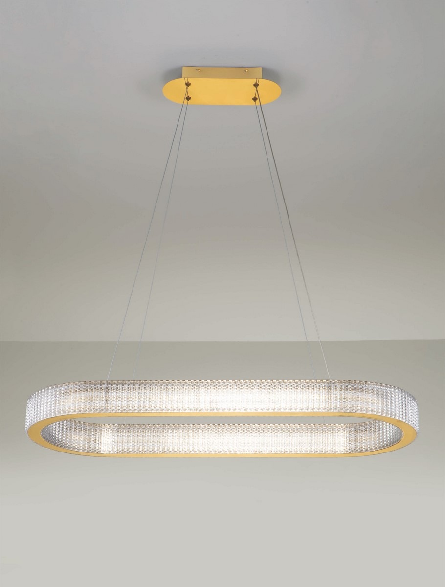 Lampa wisząca Yotau 1xLED 70W w złotej oprawie, o podłużnym kształcie. Szklany klosz z teksturą, emitujący jasne światło, zawieszony na cienkich przewodach. Montaż sufitowy na okrągłej podstawie. Tło jasne, minimalistyczne.