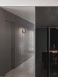 Kinkiet Zudanez 1xLED 10W w kolorze niklowym, zamontowany na gładkiej, szarej ścianie. Okrągła obudowa z metalicznym wykończeniem, w neutralnej aranżacji wnętrza, obok drzwi. Delikatne oświetlenie w tle.