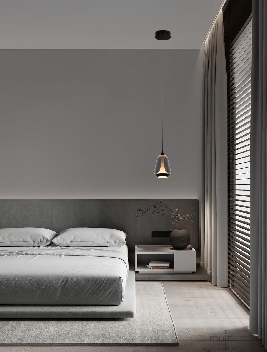 Lampa wisząca Rorizno 1xLED 8W w czarnym kolorze z przydymionym szarym kloszem, zawieszona nad łóżkiem w nowoczesnej sypialni. Klosz ma elegancki kształt, a lampa jest zamontowana na cienkim przewodzie w minimalistycznym wnętrzu.