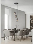 Lampa wisząca Rorizno z trzema kloszami, czarna z przydymionym szarym szkłem. Wisi na długich kablach, zawieszona na okrągłej podstawie. Idealna do nowoczesnych wnętrz, umieszczona nad stołem w jadalni. W tle szare krzesła i minimalistyczne aranżacje.