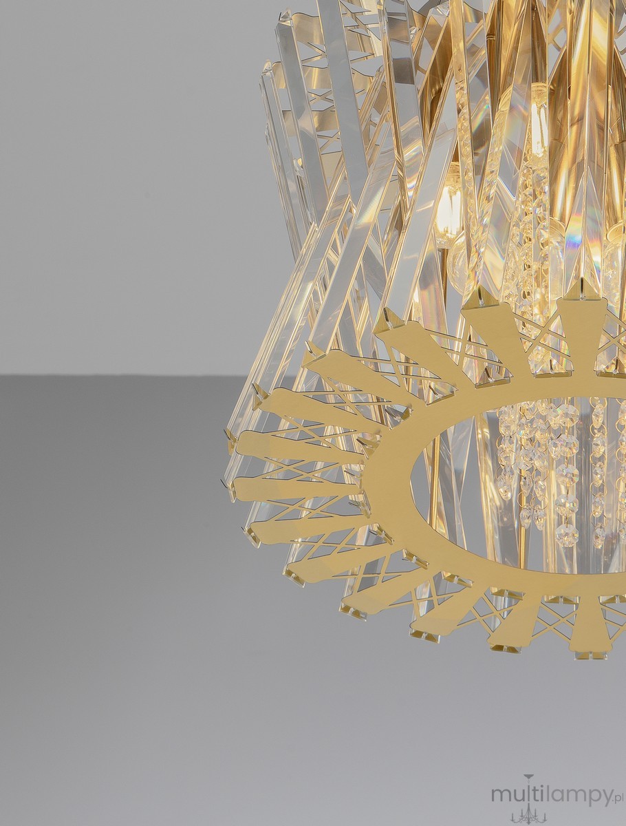 Lampa wisząca Melunto z 8 miejscami na żarówki E14, wykonana z satynowego mosiądzu. Posiada przezroczyste, szklane elementy w kształcie ostrzy oraz dekoracyjne kryształki, tworząc elegancki design. Ujęcie z góry, na jednolitym tle.