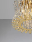 Lampa wisząca Melunto z 8 miejscami na żarówki E14, wykonana z satynowego mosiądzu. Posiada przezroczyste, szklane elementy w kształcie ostrzy oraz dekoracyjne kryształki, tworząc elegancki design. Ujęcie z góry, na jednolitym tle.