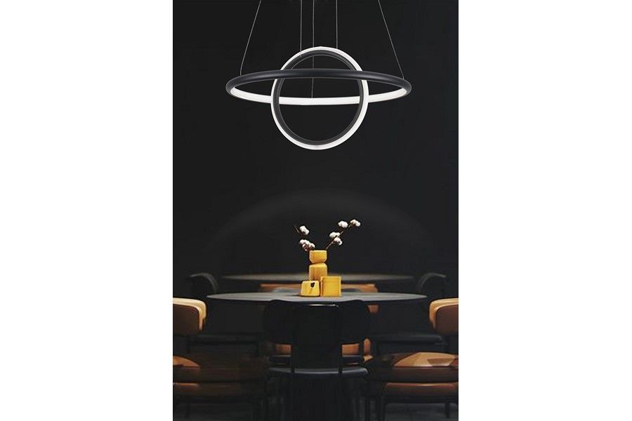 Czarna lampa wisząca LED Gravity, 36W, 4000K, z okrągłym, podwójnym pierścieniem. Zawieszona w jadalni nad stołem, w minimalistycznym stylu, na ciemnym tle. Wyróżnia się nowoczesnym designem i eleganckim wykończeniem.