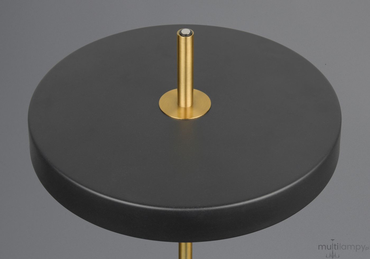 Lampa stołowa Keaton z czarnym, okrągłym stelażem i złotym metalowym detalem. Widok z góry na okrągłą podstawę oraz prostą, złotą nogę. Produkt przeznaczony do montażu z 1xLED 12W. Tło jednolite szare.