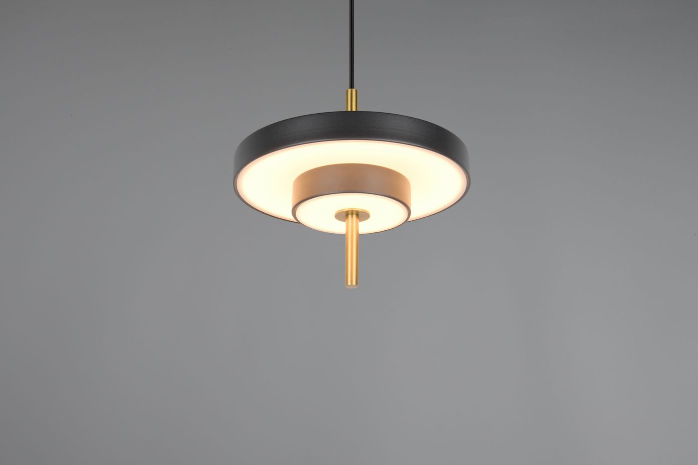 Lampa wisząca Keaton z jednym źródłem LED 10W w kolorze czarnym i złotym. Okrągła podstawa z matowym wykończeniem, z centralnym elementem w odcieniu złotym. Wisi na czarnym przewodzie, z białym, rozproszonym światłem.