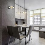 Lampa wisząca Keaton z jednym źródłem LED 34,5W w kolorze czarnym i złotym, zawieszona nad stołem w nowoczesnej kuchni. W tle widoczne meble kuchenne i okno z zasłonami.