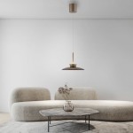 Brązowa lampa wisząca Pure Moon 2xLED 16W, z minimalistycznym kloszem, zawieszona na cienkim przewodzie. W tle widoczna nowoczesna kanapa i okrągły stół z dekoracyjną rośliną w szklanym wazonie, na jasnym tle.