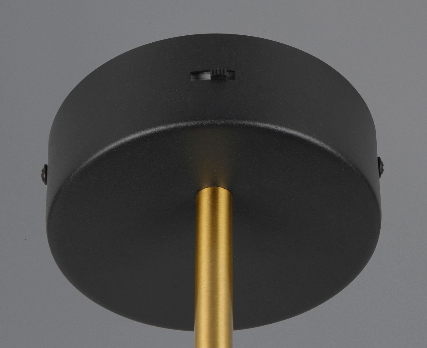 Kinkiet Keaton z czarną oprawą i złotym wykończeniem, widok od dołu. Okrągła podsufitka z matowego metalu i złoty stelaż. W górnej części widać pokrętło do regulacji. Produkt w stylu nowoczesnym, idealny do wnętrz.