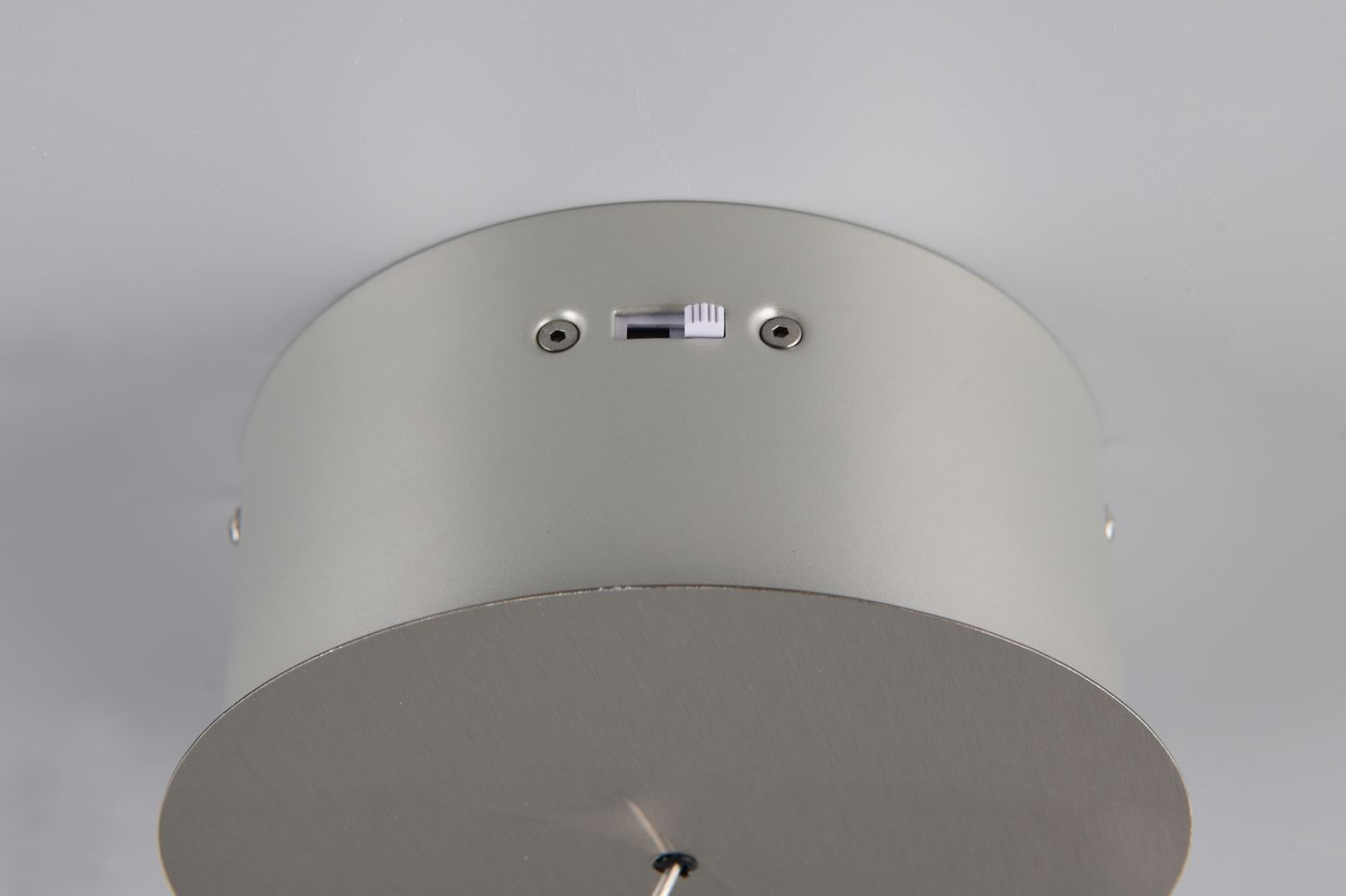 Lampa wisząca Dios w kolorze niklowym, z jedną diodą LED 8W. Widok z góry, pokazujący okrągłą podstawę z metaliczną fakturą oraz wycięcie na przełącznik. Produkt zamontowany na suficie, z widocznymi elementami mocującymi.