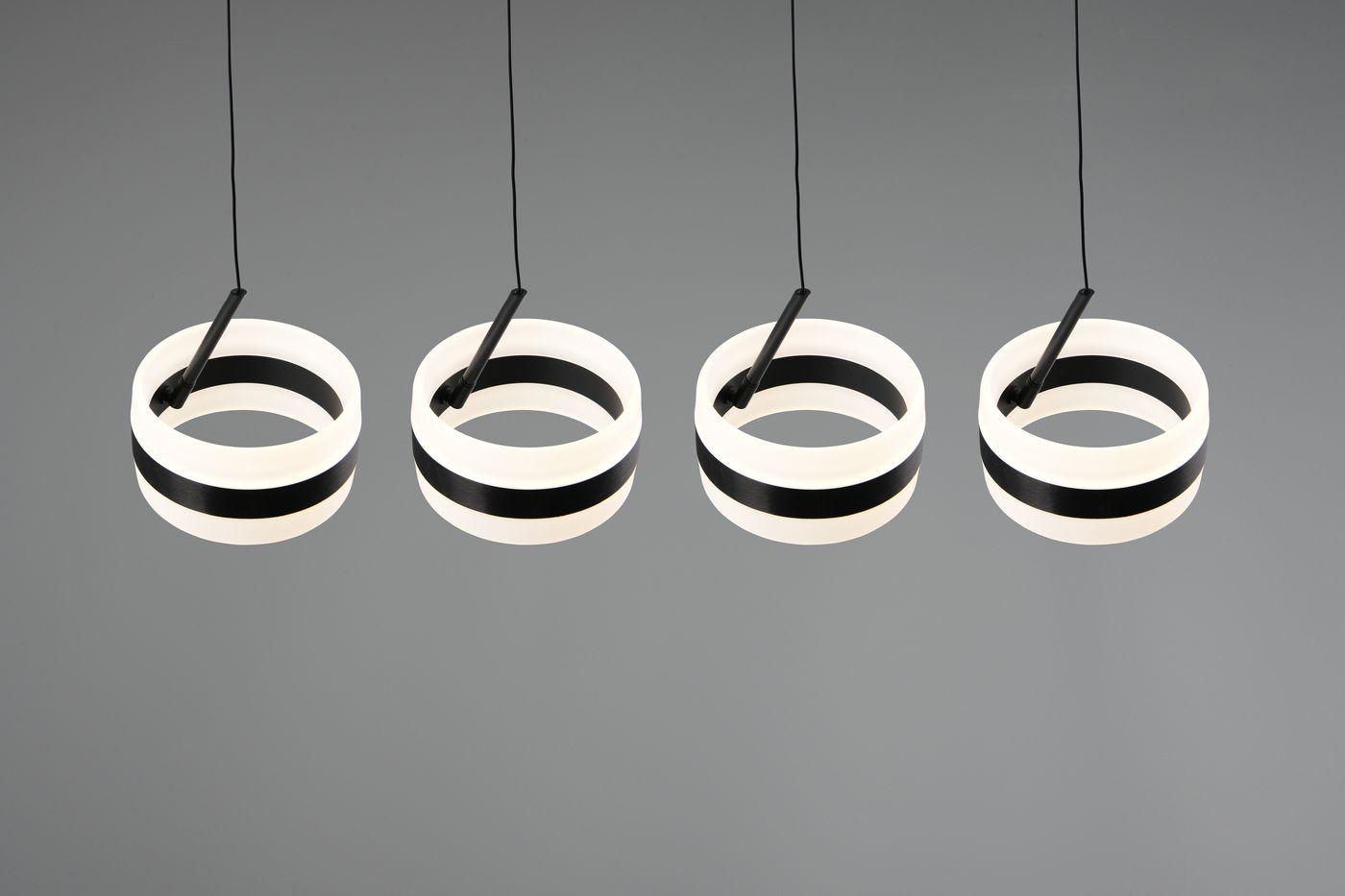 Lampa wisząca Dios z czterema okrągłymi modułami LED, czarna z białymi akcentami. Produkt zawieszony na cienkich przewodach, prezentujący nowoczesny design. Okręgi mają wyraźne czarne paski i emitują ciepłe światło.