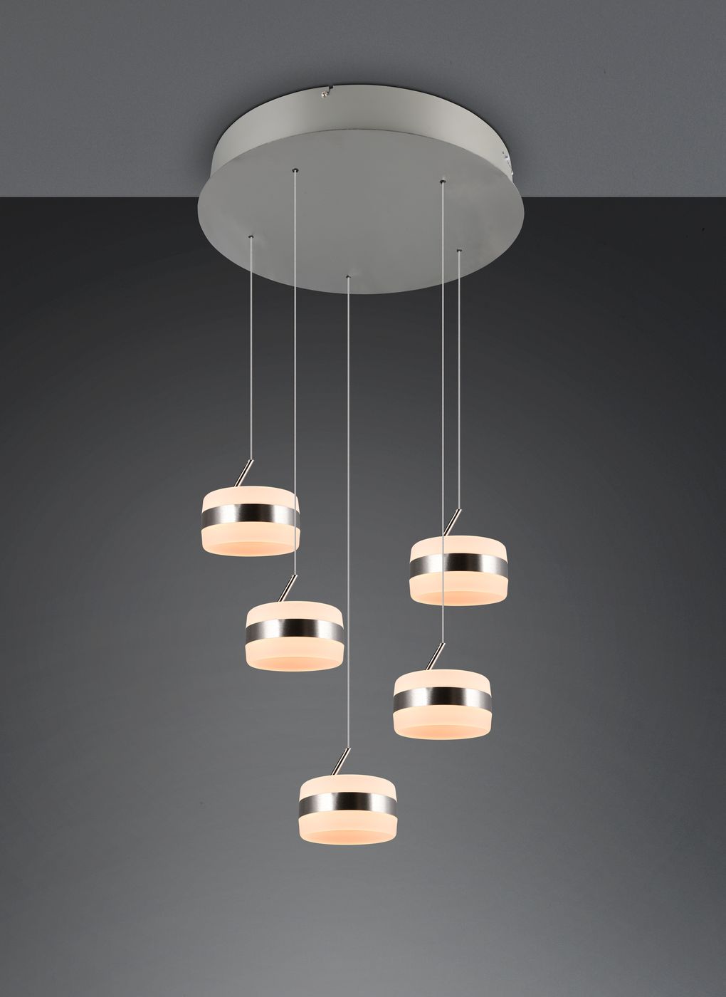 Lampa wisząca Dios z pięcioma źródłami LED o mocy 40W, kolor nikiel. Okrągłe klosze w jasnym kolorze z metalicznymi detalami, zawieszone na cienkich linkach. Ujęcie z przodu, na jednolitym tle.