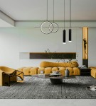 Lampa wisząca Moderno w kolorze czarnym, zawierająca dwa okręgi i trzy cylindryczne źródła światła LED, zawieszona na długich linkach w nowoczesnym wnętrzu z żółtą sofą i okrągłym stolikiem.