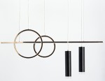Lampa wisząca Moderno z dwoma złotymi okręgami i trzema czarnymi cylindrami LED. Zawieszona na białych linkach, wyróżnia się minimalistycznym designem. Okręgi mają połyskującą złotą powierzchnię, a cylindry są matowe z metalowymi elementami.