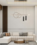 Lampa wisząca Moderno z dwoma okręgami i trzema cylindrycznymi źródłami światła LED, w kolorze złotym. Zawieszona na cienkich linkach, idealna do nowoczesnych wnętrz. Ujęcie z dołu, w tle kanapa i stolik kawowy.