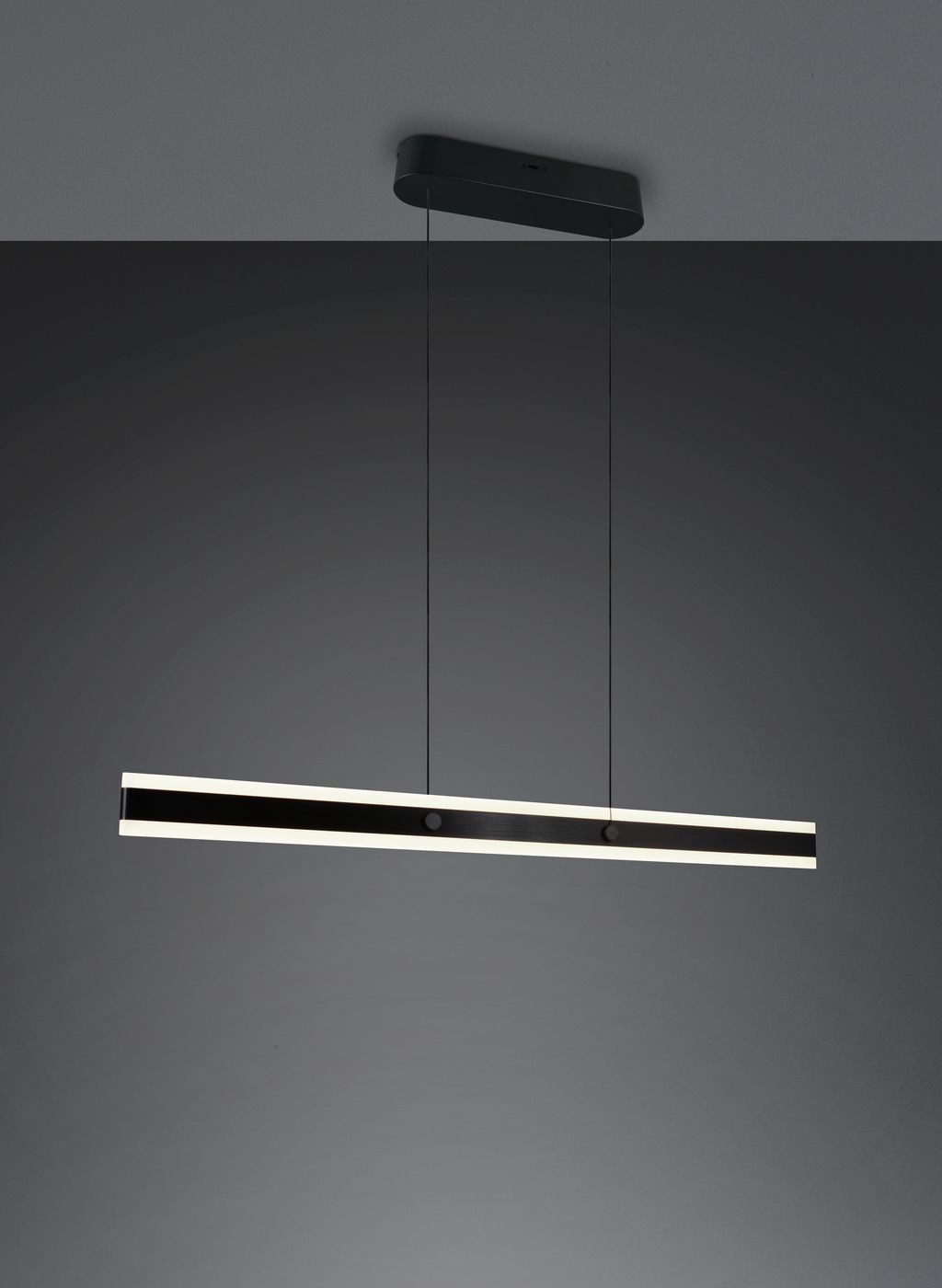 Lampa wisząca Arcola w kolorze czarnym, o długości prostokątnej z wbudowanym oświetleniem LED 35W CCT. Zawieszona na cienkich linkach, z minimalistycznym designem, idealna do nowoczesnych wnętrz.