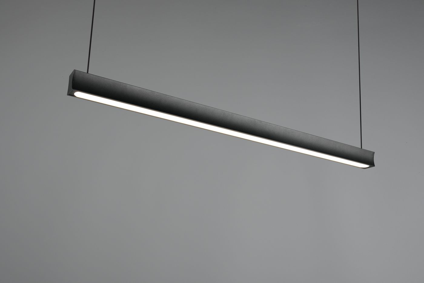 Czarna lampa wisząca Wallace z jednym źródłem LED o mocy 29W, o prostokątnym kształcie. Zawieszona na cienkich linkach, z widocznym źródłem światła wzdłuż dolnej krawędzi, na jednolitym szarym tle.