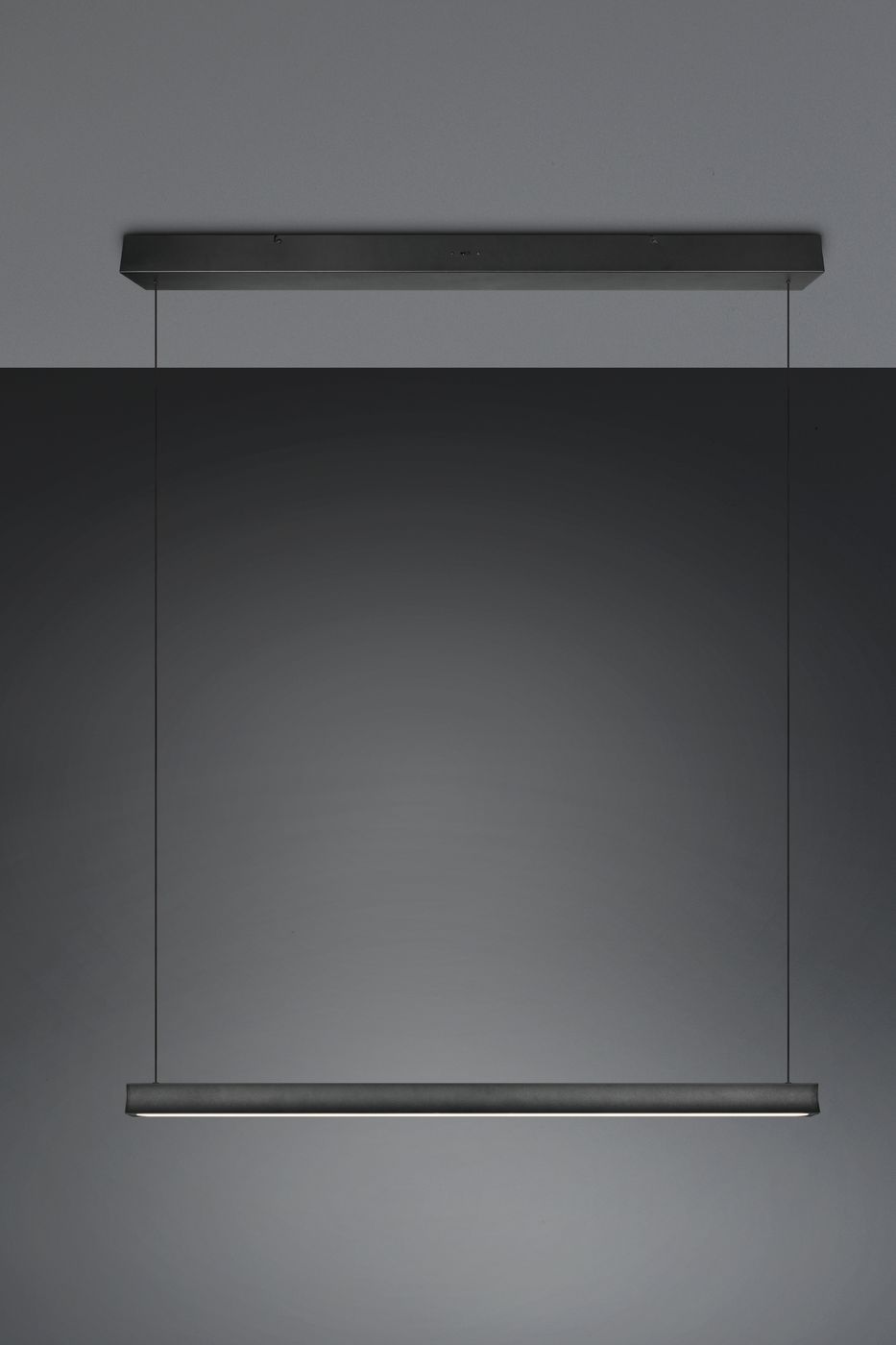Lampa wisząca Wallace 1xLED 29W CCT w kolorze czarnym, o minimalistycznym, prostokątnym kształcie. Zawieszona na cienkich przewodach, z widoczną, emitującą światło listwą LED na dolnej krawędzi. Tło w odcieniu szarości.