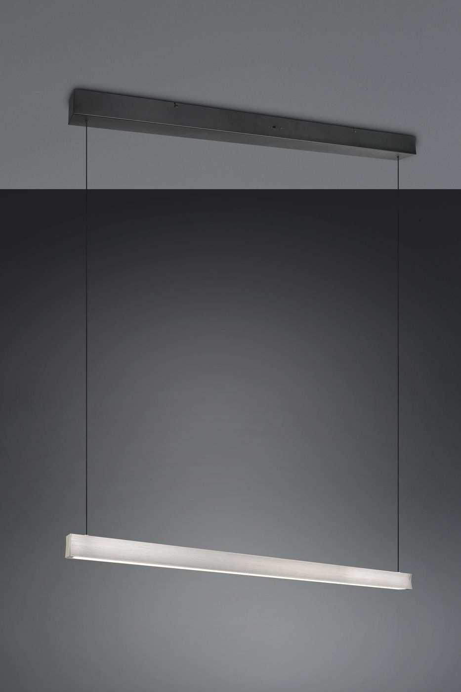 Lampa wisząca Wallace z jedną diodą LED 29W, w kolorze czarnym i niklowym, w formie prostokątnej listwy. Zawieszona na cienkich przewodach, z minimalistycznym designem, idealna do nowoczesnych wnętrz. Tło w odcieniach szarości.
