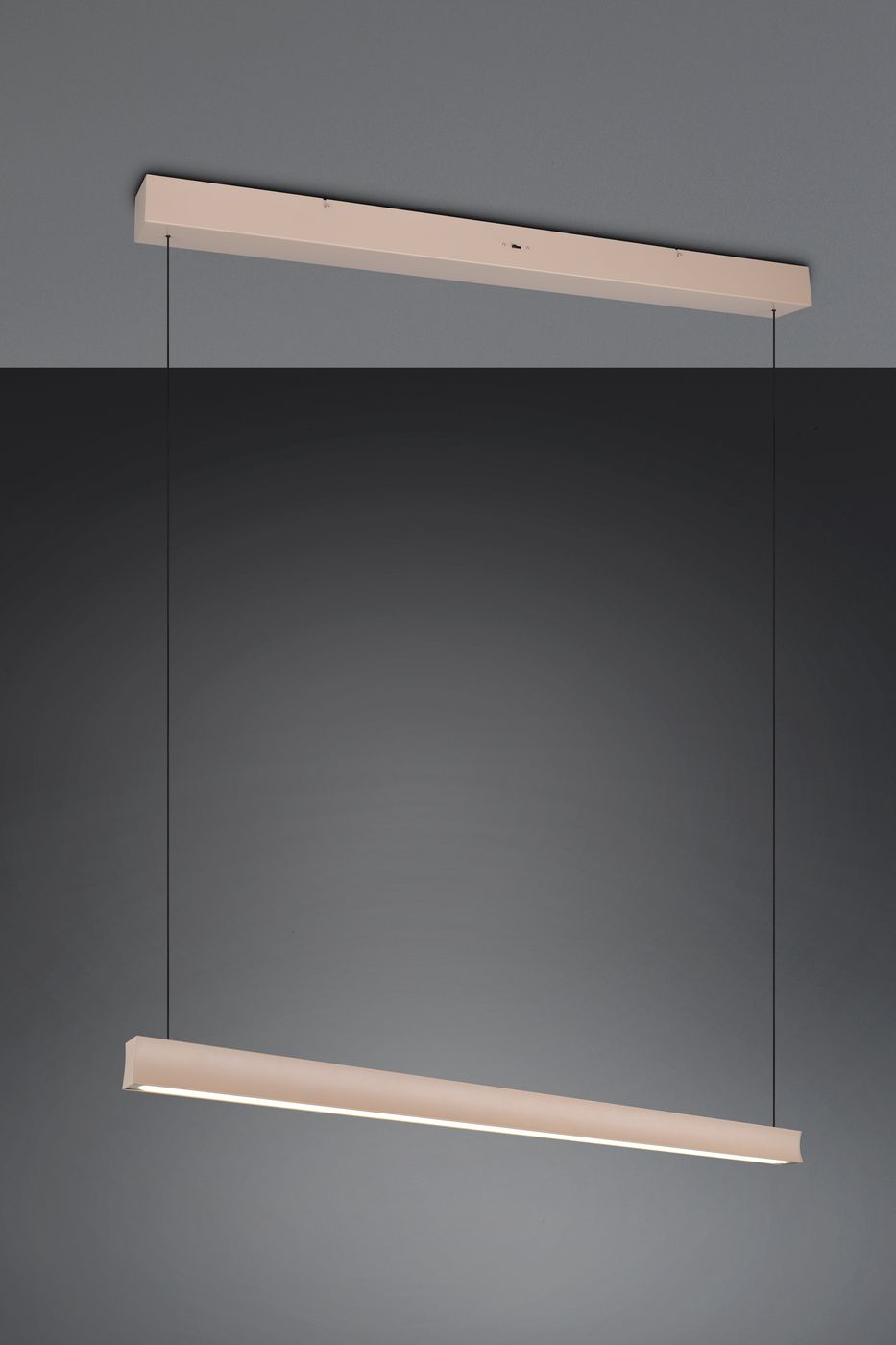Beżowa lampa wisząca Wallace z jedną diodą LED o mocy 29W, w prostokątnym kształcie, zawieszona na cienkich linkach. Widziana z przodu, z widocznym źródłem światła w dolnej części lampy, na tle ciemnoszarym.