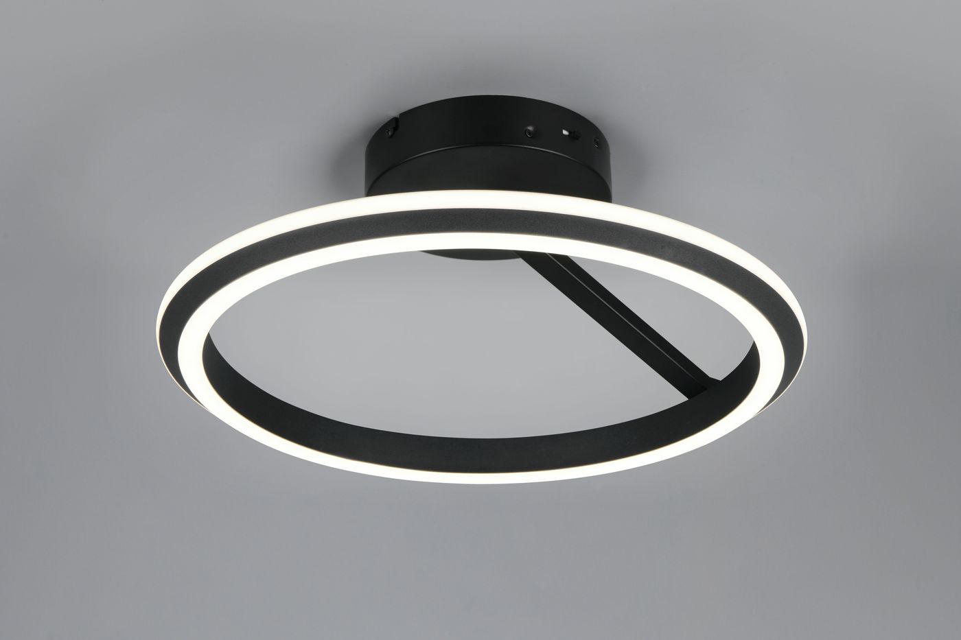 Lampa sufitowa Amador w kolorze czarnym, z jedną diodą LED 34W. Okrągła forma z dwoma pierścieniami – zewnętrznym czarnym i wewnętrznym białym. Zamontowana w górnej części, na jednolitym tle.