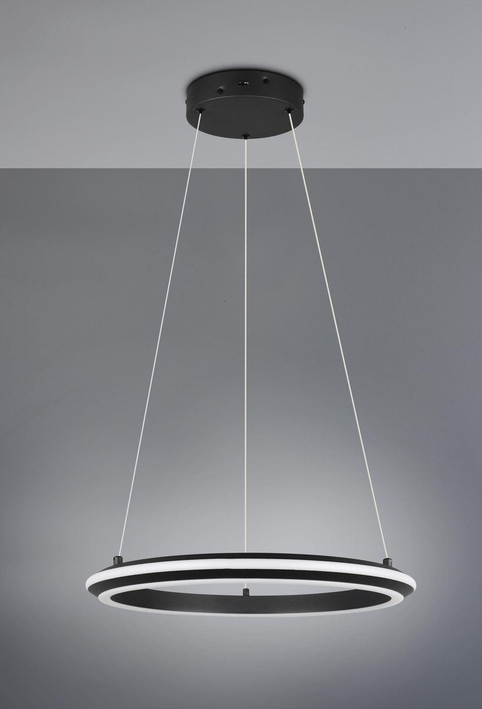 Lampa wisząca Amador 1xLED 34W CCT w kolorze czarnym, o okrągłym kształcie. Zawieszona na dwóch linkach, z widocznym podświetleniem w białym kolorze. Ujęcie z boku, na szarym tle.