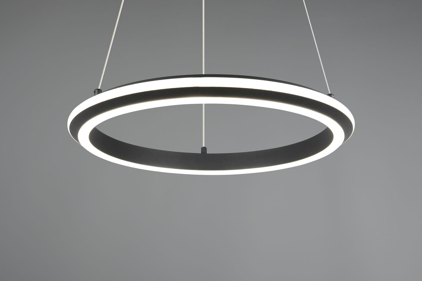 Lampa wisząca Amador 1xLED 34W CCT w kolorze czarnym, o okrągłym kształcie. Zawiera dwa pierścienie: zewnętrzny czarny i wewnętrzny z białym światłem LED. Zawieszona na cienkim sznurku, prezentuje minimalistyczny design na jednolitym tle.
