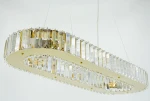 Lampa wisząca Windsor 8xE14 w kolorze złotym z przezroczystymi dekoracjami. Posiada owalny kształt z kryształowymi elementami, zawieszona na cienkich linkach. Widoczny detal w postaci złotych mocowań oraz błyszczących powierzchni.