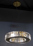 Lampa wisząca Windsor 4xE14 w kolorze złotym, z okrągłym kloszem z przezroczystych kryształków. Montowana na suficie, z widocznymi elementami elektrycznymi. Efektowny design, idealna do nowoczesnych wnętrz.
