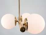 Lampa sufitowa Otis 3xE27 w złotym wykończeniu, z trzema okrągłymi kloszami z matowego szkła. Ujęcie z góry, pokazujące detale mocowania i błyszczące elementy metalowe. Produkt zawieszony, na jednolitym tle.