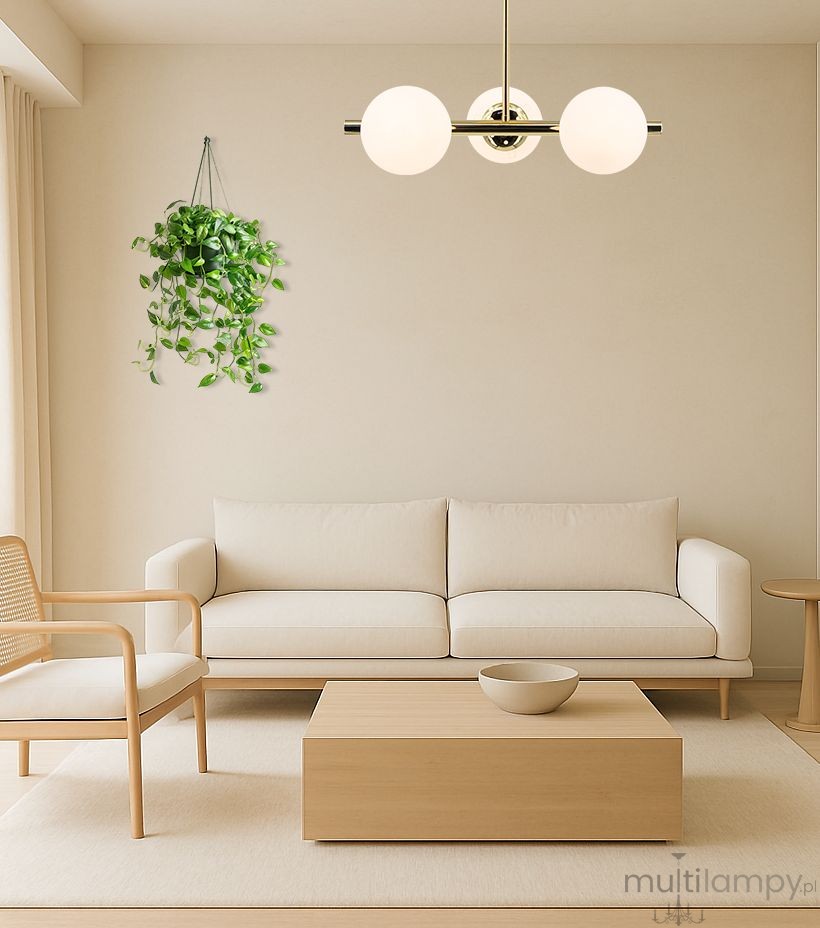 Lampa sufitowa Otis 3xE27 w kolorze złotym, z trzema okrągłymi kloszami w białym kolorze, zamontowana na prostym, złotym stelażu. Widoczna w jasnym wnętrzu z kanapą i stolikiem, zawieszona centralnie nad meblami.