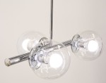 Lampa wisząca Otis 3xE27 w chromowanej oprawie. Posiada trzy przezroczyste klosze w kształcie kul, zawieszone na metalowej rurze. Widoczne źródła światła o jasnym blasku, umieszczone w kloszach. Tło jasne, co podkreśla elegancki design.