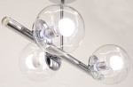 Lampa wisząca Otis z trzema kloszami w kształcie kul, wykonana z przezroczystego szkła. Chromowany metalowy stelaż, z widocznymi gniazdami E27. Kąt ujęcia z dołu, ukazujący detale konstrukcji i źródła światła. Tło jasne, minimalistyczne.