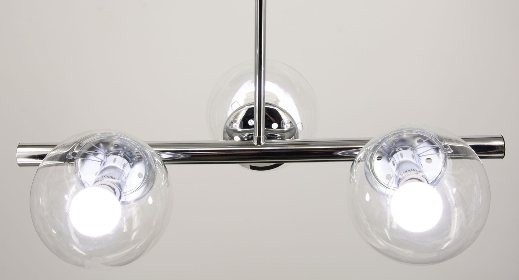 Lampa wisząca Otis z trzema dużymi, szklanymi kloszami w chromowanej oprawie. Widok z góry ukazuje metalowy wspornik oraz źródła światła E27. Klosze mają okrągły kształt, przezroczyste, z wyraźnie widocznymi żarówkami.