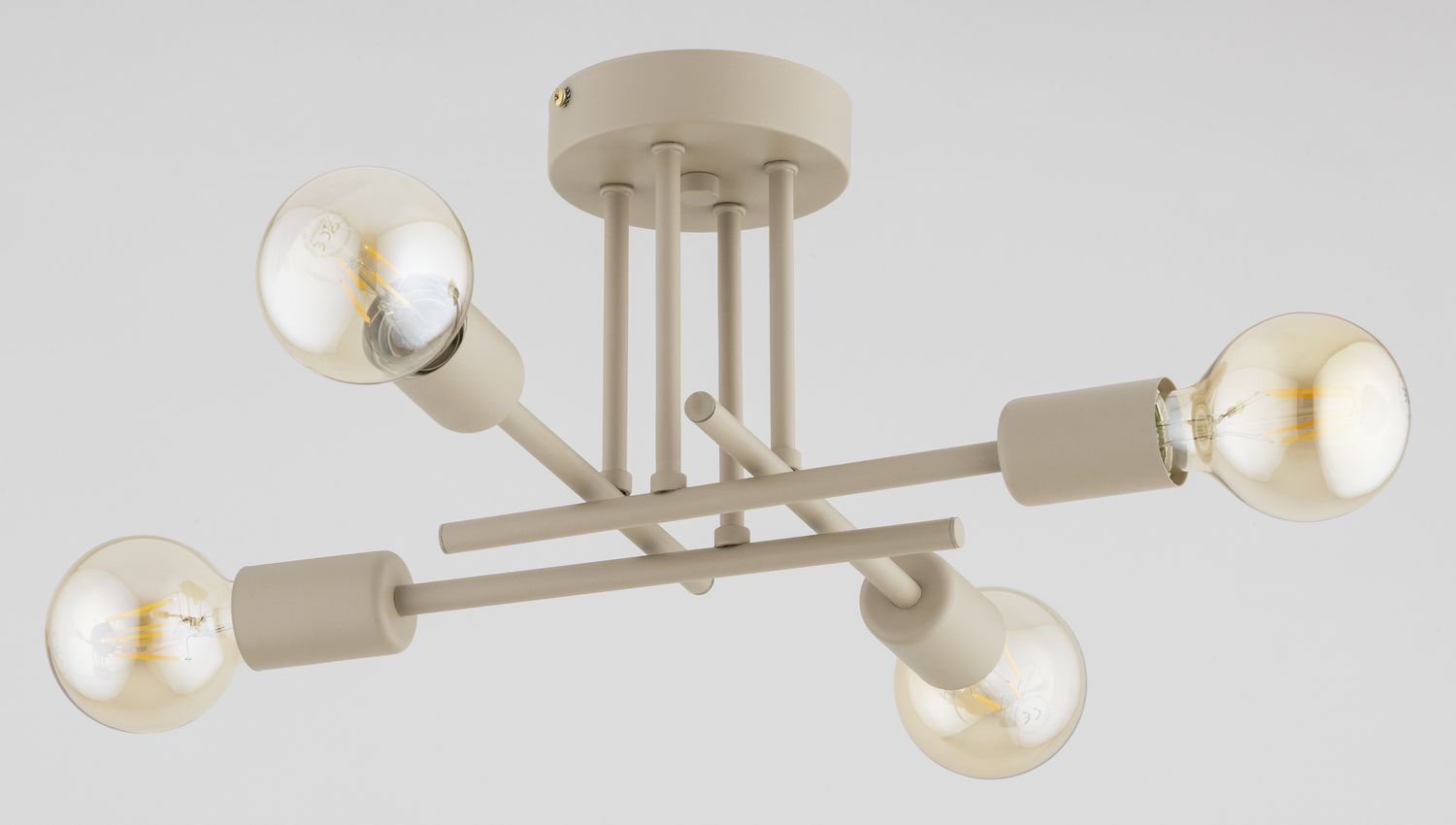 Lampa sufitowa Dakar w kolorze taupe, z czterema oprawami na żarówki E27. Wyposażona w metalową konstrukcję z poziomymi i pionowymi ramionami, zamontowana na okrągłej podstawie. Świecące, przezroczyste żarówki podkreślają nowoczesny design.