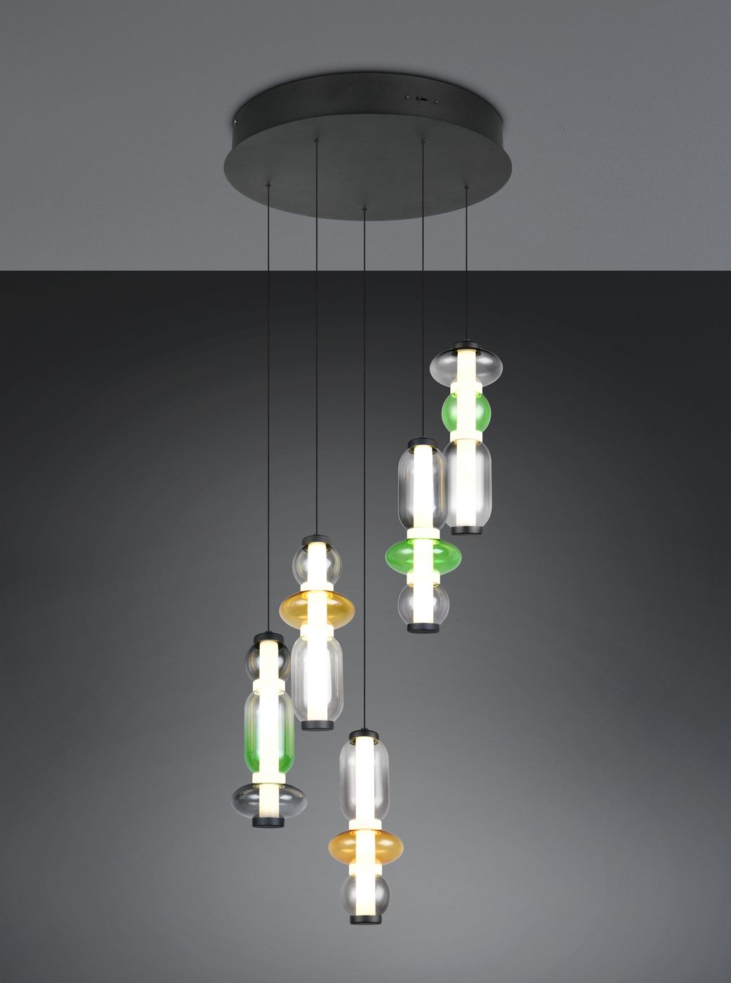 Lampa wisząca Minerva z pięcioma źródłami LED o mocy 40W, w kolorze czarnym, z multikolorowymi kloszami w kształcie cylindrów. Ujęcie z dołu, pokazujące różne kolory kloszy: zielony, żółty i przezroczysty, zawieszone na cienkich linkach.