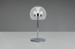Lampa stołowa Flynt z przezroczystą, zaokrągloną kloszem i chromowaną podstawą. Ujęcie frontalne, stojąca. Wbudowana dioda LED 8W CCT. Prosty, nowoczesny design, na jednolitym tle.