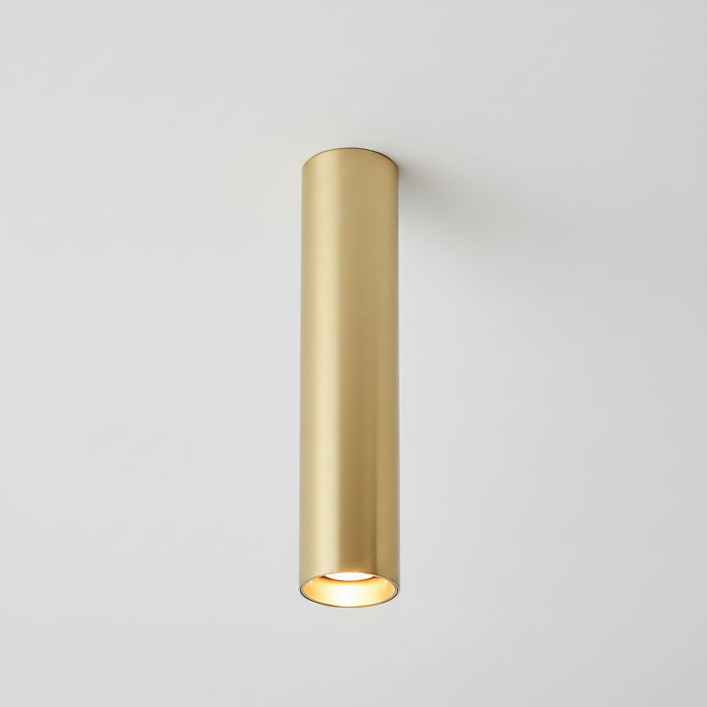 Lampa sufitowa Genesis H20 w kolorze złotym, wykonana z metalowego materiału, w kształcie cylindrycznym. Zawiera mocowanie na żarówkę GU10, zamontowana na białym suficie, widoczna z przodu.