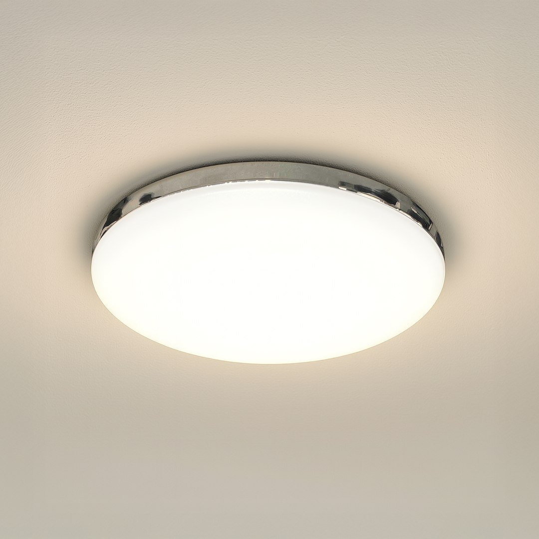 Plafon LED Maya D33 w kolorze chromu, o średnicy okrągłej, z mleczną, matową pokrywą. Posiada moc 15W, barwę światła 4000K i klasę ochrony IP44. Zawieszony na gładkim, jasnym tle, widoczny z góry.
