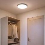 Maya LED D33 plafon o średnicy 33 cm, chromowany, z białym kloszem, o mocy 15W i temperaturze barwowej 4000K. Zainstalowany na suficie w minimalistycznym wnętrzu z szafą i ubraniami w odcieniach beżu.