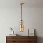 Lampa wisząca Molly z jedną oprawą E14, w kolorze złotym i bursztynowym, zawieszona na czarnym przewodzie. Posiada szklany klosz o bursztynowym odcieniu oraz dekoracyjny, zielony element u góry. W tle widoczna komoda z książkami i wazonem.