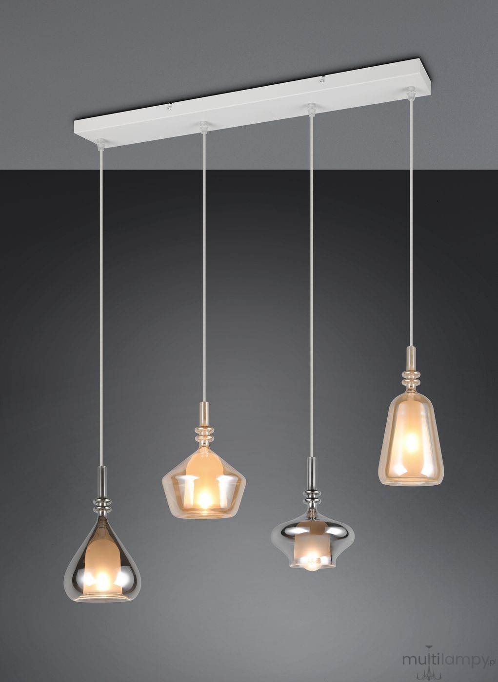 Lampa wisząca Aldea z czterema kloszami w różnych kształtach, wykonana z przezroczystego szkła i metalu, zawieszona na białej listwie. Klosze w kolorze szarym, złotym i srebrnym emitują ciepłe światło. Ujęcie z przodu, w neutralnym tle.