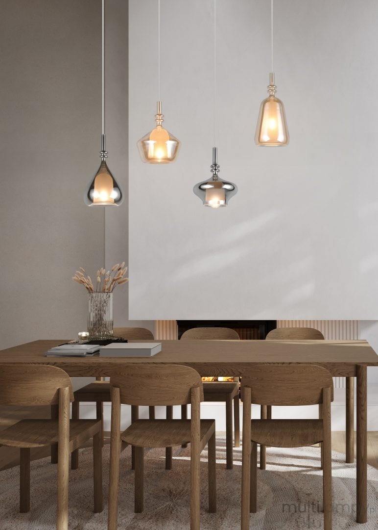 Lampa wisząca Aldea z czterema kloszami E14 w białym i multikolorowym wykończeniu. Klosze o różnych kształtach zawieszone na długich linkach, umieszczone nad drewnianym stołem w nowoczesnym wnętrzu. Tło jasne, minimalistyczne.